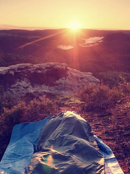 Sleeping in nature in sleeping bag. Beautiful awakening in  rocks. View from rocky peak