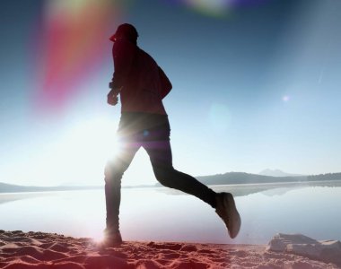 Kaçak ışık objektif. . Çalışan adam. Koş, sporcu adam kumlu bir plaj üzerinde gündoğumu sırasında koşu.