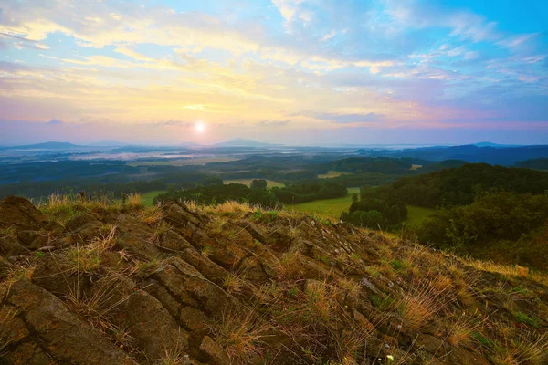 Acantilados agudos. Pico rocoso de basalto en la colina. Valle del bosque y sol por encima del horizonte . — Foto de Stock