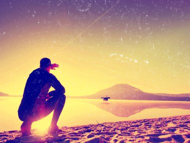 Film etkisi. Adam sahilde egzersiz. Egzersiz ve göl kumsalda güneş doğarken germe etkin adam silüeti.