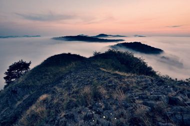 Sisli rüya gibi manzara sonbahar başında. Ağır Sis çayır, tepeler ve kasaba ufuktan. 