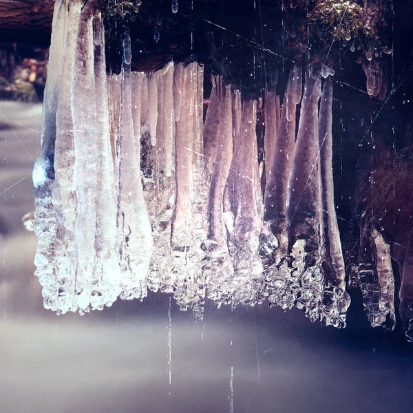 Film effect. Winter creek met ijspegels bovenstaande bevriezen bergbeek. Winterseizoen bij rivier, shinning ijspegels — Stockfoto