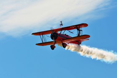 Memorial Airshow. Sergide duman takip ederken kamera doğru uçan kırmızı Stearman çift kanatlı