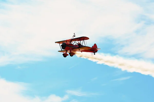 Memorial de Airshow. Red Stearman dubbeldekker vliegen naar camera terwijl achterstand rook in de tentoonstelling — Stockfoto
