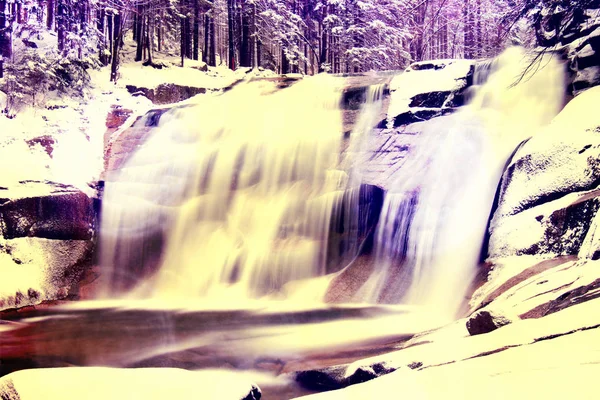 Effet film. Vue d'hiver sur les rochers enneigés à cascade de cascade... Flux en surgélation . — Photo