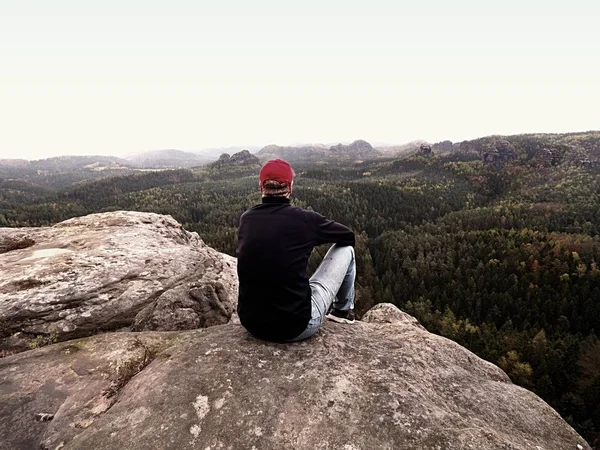 Homem turista sentar no pico da montanha. Cena de montanha de viagem. Caminhante descansar sozinho na montanha — Fotografia de Stock