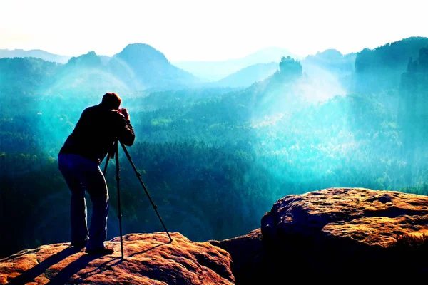 Cereale de film. Profesionist pe stâncă. Fotograful de natură face fotografii cu camera oglindă pe vârful muntelui — Fotografie, imagine de stoc