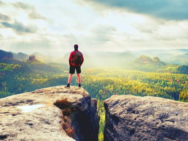 Uzun boylu adam tepe dağ kenar üzerinde özgürlük keyfini çıkarın. Yalnız turist puslu Vadisi izlerken 