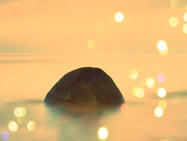 Film hatása. Hosszú expozíció a tenger és a nagy sziklák ragadt víz twilight időn belül. Rózsaszín naplemente a tengeren Balsitc sziklás part. — Stock Fotó