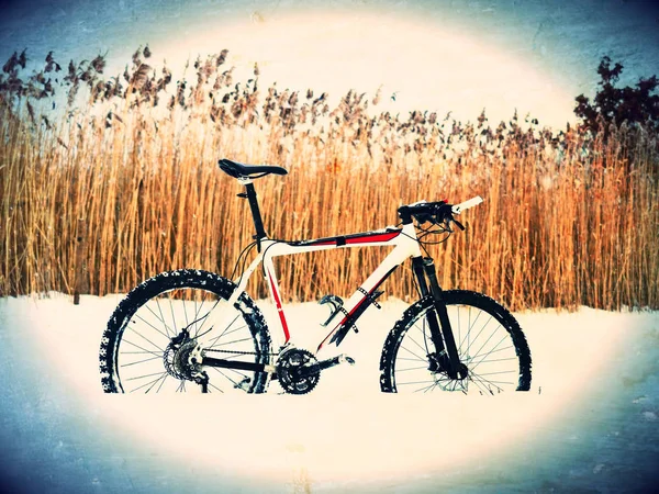 Film effekt. Mountainbike bo i pudersnö. Förlorade sökvägen i djupa snödriva. Bakre hjul detalj. Snöflingor smältande på mörk off road däck. — Stockfoto