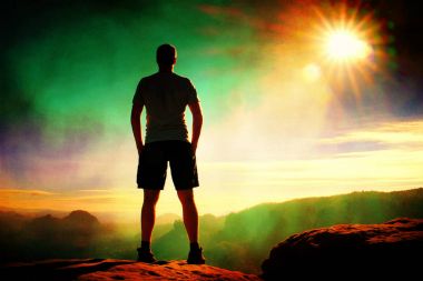 Film tahıl. Yalnız siyah pantolon uzun yürüyüşe çıkan kimse ayağa rock İmparatorluğu ve güneş güzel an puslu ve sisli sabah Vadisi'ne üzerinden izlerken doğa mucizesi 