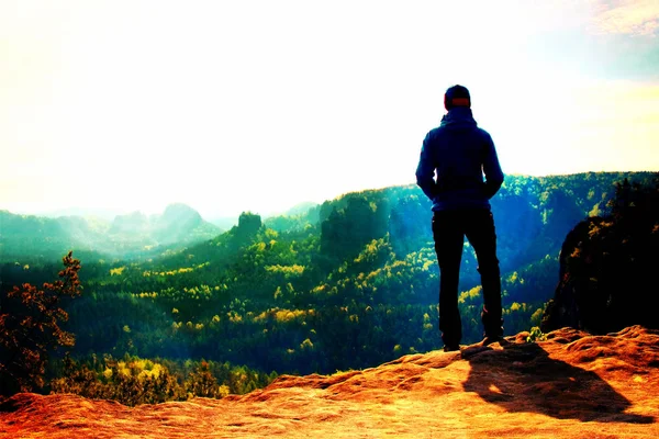 Film grain. Alone young girl tourist feast daybreak on the sharp corner of sandstone rock and watch over valley to Sun. — Stock Photo, Image