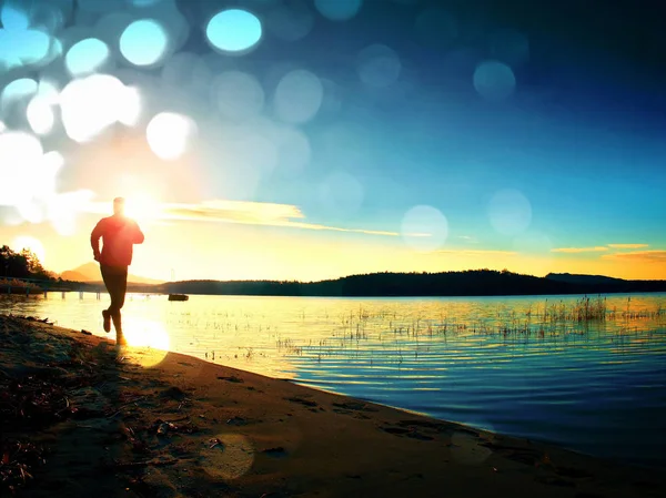 Filmkorrel. Lopende mens. Sportman loper, joggen man tijdens de zonsopgang boven zandstrand — Stockfoto