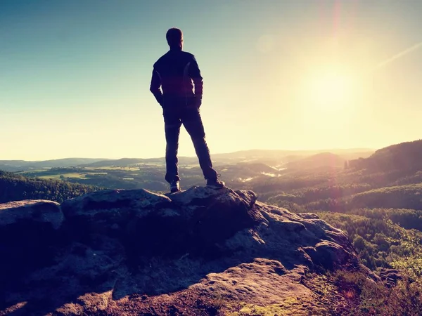 L'homme se tient sur le sommet du rocher de grès qui veille sur la vallée jusqu'au Soleil. Beau moment — Photo