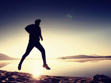 Uzun kumsalda hızlı deniz kıyısında koşan adam uygun. Güçlü runner yaz sabah açık eğitim.