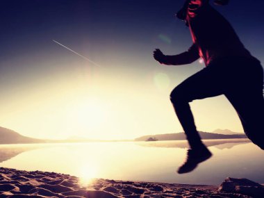Uzun kumsalda hızlı deniz kıyısında koşan adam uygun. Güçlü runner yaz sabah açık eğitim.