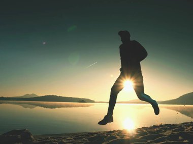 Uzun kumsalda hızlı deniz kıyısında koşan adam uygun. Güçlü runner yaz sabah açık eğitim.