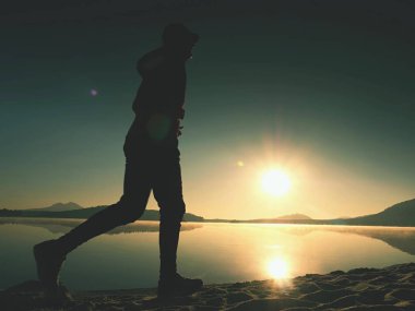 Uzun kumsalda hızlı deniz kıyısında koşan adam uygun. Güçlü runner yaz sabah açık eğitim.