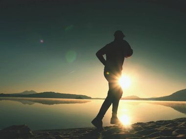 Uzun kumsalda hızlı deniz kıyısında koşan adam uygun. Güçlü runner yaz sabah açık eğitim.