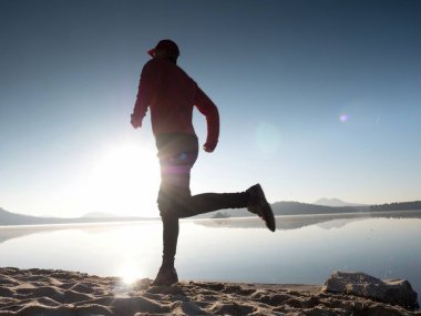 Uzun kumsalda hızlı deniz kıyısında koşan adam uygun. Güçlü runner yaz sabah açık eğitim.