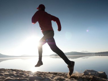 Güzel bir gün batımı fon karşı sahilde koşan adam. Kum dağ gölü