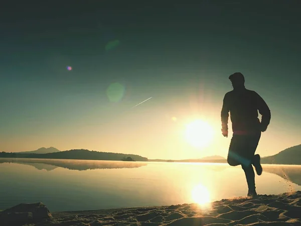Tall zmieścić człowiek działa szybko nad morzem na plaży. Szybkiego biegacza szkolenia odkryty w letni poranek. — Zdjęcie stockowe