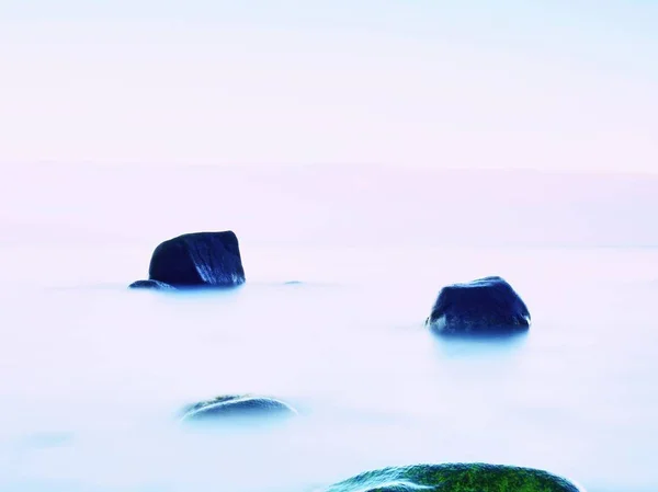 Tout le monde aime l'atmosphère romantique de la mer. Niveau de la mer paisible, pierres dans l'eau — Photo