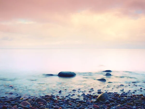 Steniga stranden på ön i romantiska färger av tropisk solnedgång — Stockfoto