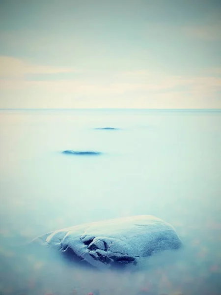 Todo el mundo ama la atmósfera romántica del mar. Nivel pacífico del mar, piedras en el agua — Foto de Stock