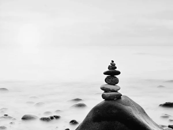 Rounded colorful stones stand in the form of pyramid big rounded stone at sea — Stock Photo, Image