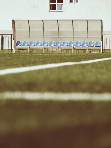 आउटडोर स्टेडियम खिलाड़ियों बेंच पर नई नीली प्लास्टिक सीटें, पारदर्शी प्लास्टिक छत के नीचे कुर्सियां — स्टॉक फ़ोटो, इमेज