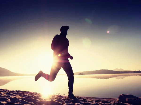 Homme courant sur la plage au coucher du soleil — Photo