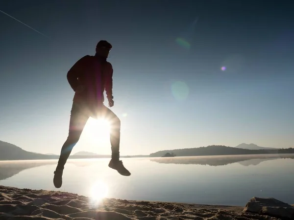 Mężczyzna biegający po plaży o zachodzie słońca — Zdjęcie stockowe