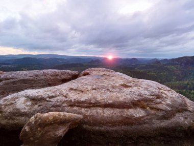 Sabah görünüm kırık kumtaşı cliff orman vadiye, ufuktan ağır bulutlar güneş hiddein.