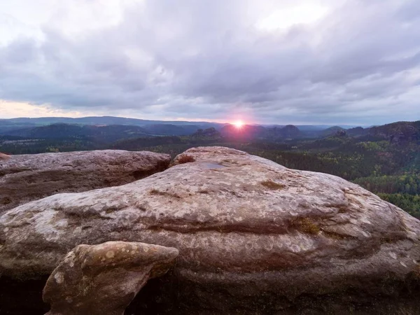 Sabah görünüm kırık kumtaşı cliff orman vadiye, ufuktan ağır bulutlar güneş hiddein.