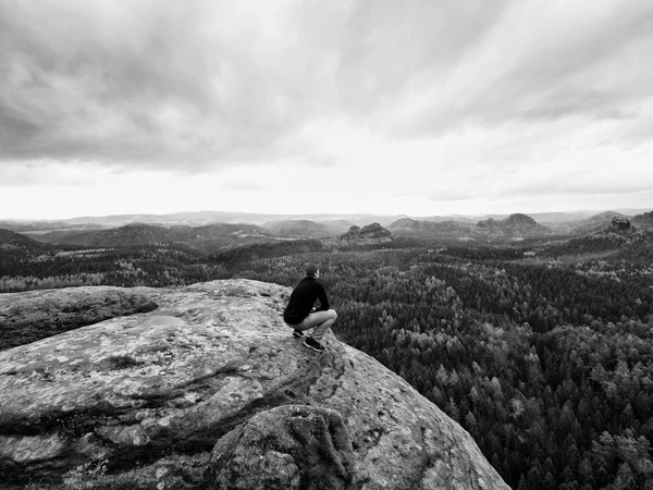 Blick zum Horizont. Mann sitzt auf Felsen über dichten Wäldern oder Dschungel und genießt Aussicht. — Stockfoto