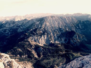 Alp cliff ve vadi üzerinde görüntüleyin. Ufuk, mavi gökyüzü ile birkaç bulutlar güneşe. Alp Dağları 