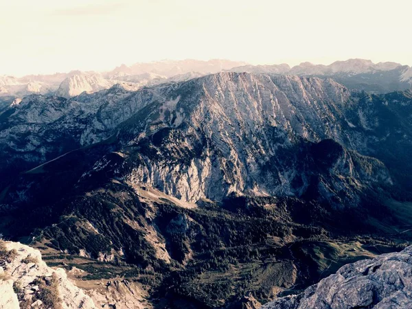 View over Alpine  cliff and valley. Sun at horizon, blue sky with few clouds. Alps mountains — Stock Photo, Image