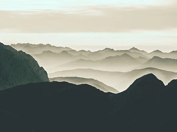 Vue aérienne spectaculaire sur les silhouettes montagneuses et les vallées brumeuses. Misty réveil de belle vallée de fées — Photo