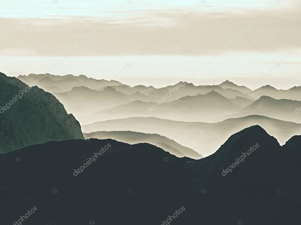 Spectacular aerial view of mountain silhouettes and misty valleys. Misty awaking of beautiful fairy valley