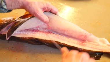 Taze balık hazırlık yakaladı. COD kesilmiş eller balık, kaldırmak ve karaciğerleri kontrol edin. Ellerini iç organlar ve fileto ayrılması kemik üzerinden kontrol. Palet, solungaçları, kesilmiş eller balık karaciğer, bağırsaklar kaldırma kontrol. 