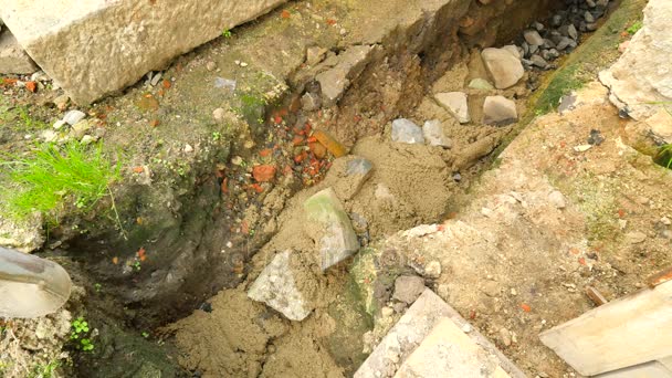 Verter, poniendo hormigón en los cimientos de la casa utilizando pala de cemento y piedras. Edificio, trabajo de hormigón en base. Alineación de la solera de hormigón. Verter cemento en la zanja del suelo . — Vídeos de Stock