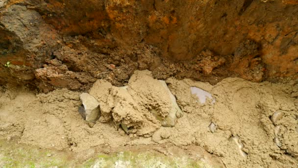 Verser, poser du béton dans les fondations de la maison à l'aide d'une pelle de ciment et de pierres. Bâtiment, travaux en béton en base. Alignement de la chape de béton. Verser du ciment dans la tranchée du sol . — Video