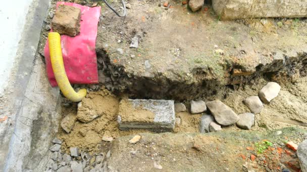 Gießen, Beton in Fundamente des Hauses mit Schaufel von Zement und Steinen legen. Bau, Betonarbeiten im Sockel. Ausrichtung des Betonestrichs. Zement in den Erdgraben gießen. — Stockvideo