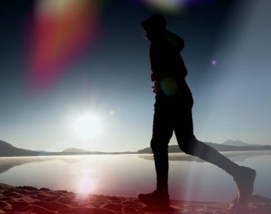 Kaçak ışık objektif. Sabah güneş karşı adam siluet egzersiz.