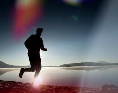 Kaçak ışık objektif. Sabah güneş karşı adam siluet egzersiz.