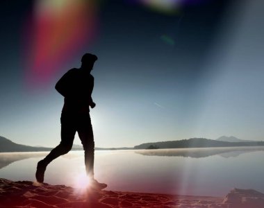 Kaçak ışık objektif. Sabah güneş karşı adam siluet egzersiz.