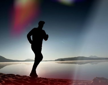 Kaçak ışık objektif. Sabah güneş karşı adam siluet egzersiz.