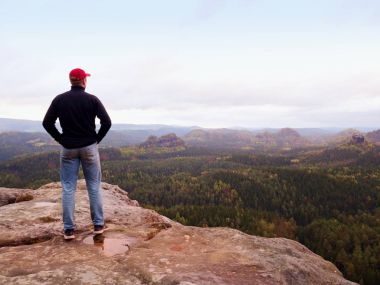 Uzun yürüyüşe çıkan kimse adam kayalık bir sırt üzerinde kalır ve üzerinde ufuk uzun vadiye manzarasının tadını çıkarın. Soğuk bulutlarda gizli güneş