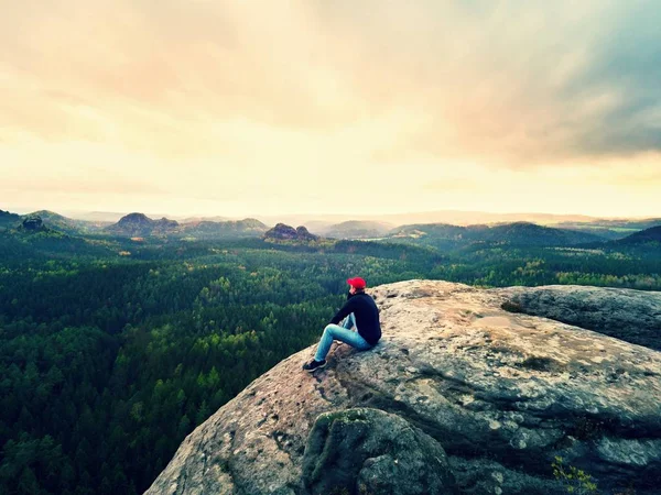 Looking to horizon. Man sit on rock above dense forests or jungle and enjoy view. — Stock Photo, Image